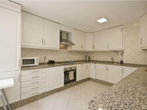 uma cozinha com armários brancos e um forno com placa de fogão em Casa em Lisboa em Lisboa