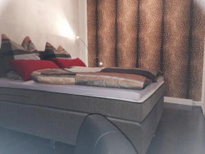 a bed with red and black pillows on it at Ferien Suite Braunlage in Braunlage