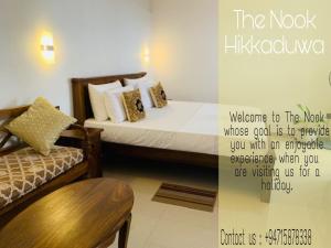 a hotel room with a bed and a chair at The Nook in Hikkaduwa