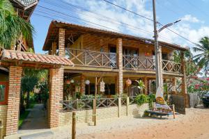 een stenen huis met een balkon in een straat bij Casa do velejador in Barra Grande