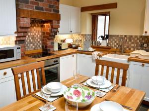 uma cozinha com uma mesa de madeira com um prato em Hilltoft Barn em Dockray