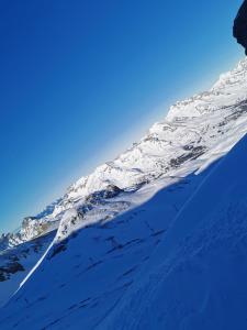 une montagne enneigée avec un ciel bleu en arrière-plan dans l'établissement Joli studio terrasse face aux pistes, à Superdevoluy