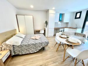 1 dormitorio con 1 cama, mesa y sillas en Hospedaje24 - 3, en Manresa