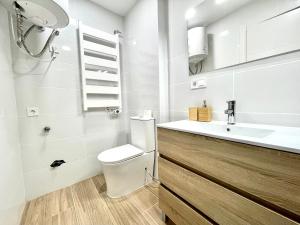 La salle de bains blanche est pourvue de toilettes et d'un lavabo. dans l'établissement Hospedaje24 - 3, à Manresa