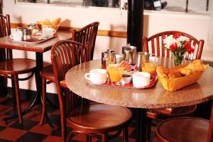 a table with breakfast foods and drinks on it at Hôtel Marignan in Paris