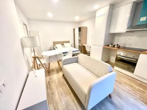 a living room with a white couch and a kitchen at Precioso loft en Manresa 3 in Manresa