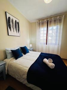 een slaapkamer met een groot bed en handdoeken bij Nogueira Country House in Fundão