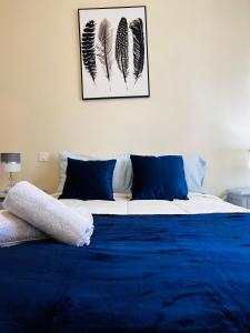 een slaapkamer met een bed met blauwe lakens en veren bij Nogueira Country House in Fundão