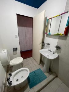un baño con inodoro y lavabo en Lipi House Hostel, en Capilla del Monte
