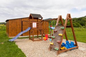 a playground with a slide and a play structure at DOMKI TU I TERAZ in Szczawnica