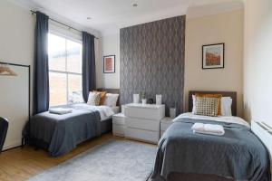 a bedroom with two beds and a window at Two Bedroom Apartment in Tooting in London