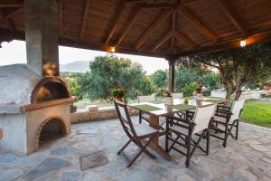 a patio with a table and an outdoor oven at Villa Manoutsio in Episkopí- Rethimno