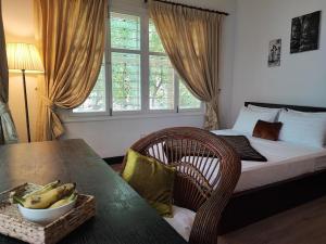 a bedroom with a bed and a table with a bowl of bananas at Villa Papillon in Phnom Penh