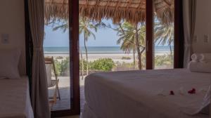 Un dormitorio con una cama y vistas a la playa. en Villa Kabaceiras, en Tatajuba