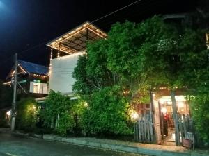 a house with a tree in front of it at night at Kwan Eng Homestay in Phayao