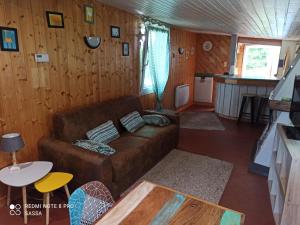 sala de estar con sofá y cocina en Les abris de la hulotte, en Anould