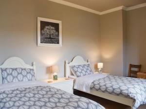 a bedroom with two beds and a picture on the wall at Hallams Yard in Skipton
