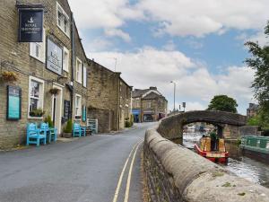 a small boat on a river next to a bridge at Hallams Yard in Skipton