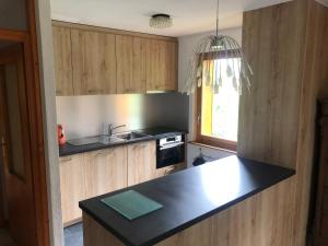uma cozinha com armários de madeira e um balcão preto em Monteilly A6 em Champéry