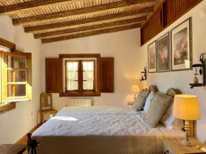 a bedroom with a large bed with a wooden ceiling at Cottage da Minha Terra 1890 près d'un lac in Geres