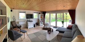 a living room with a couch and a table at Spacey and charming cabin 300 m. from beach in Tjørneholm