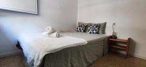 a bedroom with a bed with a towel on it at Casa Petits in Manresa