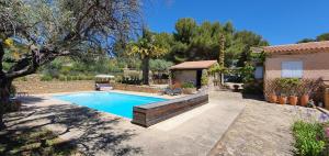 een zwembad in een tuin met een huis bij Le Mas des Vignes in Bandol