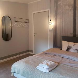 Schlafzimmer mit einem Bett mit einem Spiegel und einer Tür in der Unterkunft Varangertunet bed & breakfast in Jakobselv