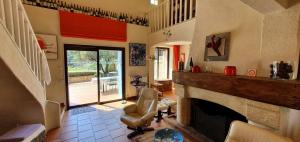 een woonkamer met een open haard en een stoel bij Le Mas des Vignes in Bandol