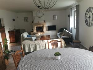 a living room with a table and a fireplace at Aux portes du Luberon in Cheval-Blanc