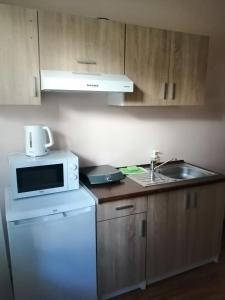 a kitchen with a white microwave and a sink at Widokowa Apartament in Szczecin