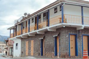 un edificio con puertas azules y naranjas y balcón en Pousada Tesouro de Minas - Centro Histórico, en Tiradentes