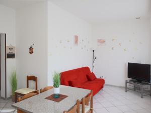 un soggiorno con divano rosso e tavolo di [Relax&Natura] a 5 minuti da BRESCIA Wifi+ Netflix a Rezzato