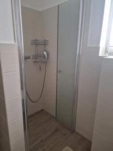 baño con cabina de ducha con manguera en Haus Lena, en Ostseebad Sellin