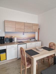 cocina con mesa de madera, mesa y sillas en Haus Lena, en Ostseebad Sellin