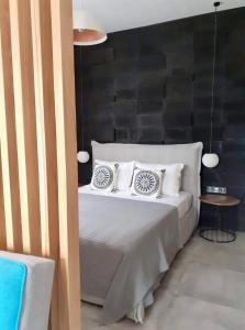 una camera da letto con un letto bianco e una parete nera di Marton Perissa a Perissa