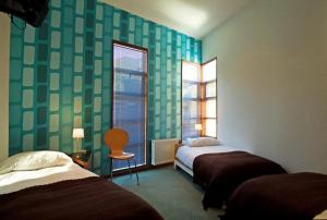 Habitación de hotel con 2 camas y ventana en Hotel Latitud 33º Sur, en Valparaíso