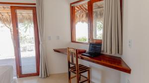 a room with a desk with a laptop and a window at Villa Kabaceiras in Tatajuba