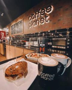 a coffee shop with a sandwich and a cup of coffee at Grand Atrium Designer Apartment in Faisalabad