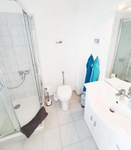 a white bathroom with a toilet and a shower at Ferienwohnung Gartenblick - Idylle am Travetal in Bad Oldesloe +5 photos