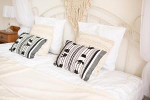 a white bed with black and white pillows on it at HOTEL LEMONIADA in Lućmierz