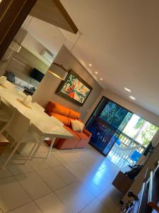 a living room with a table and a couch at Apartamento Barra Bali in Barra de São Miguel