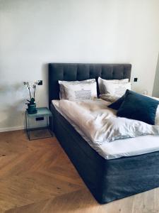 a bed with a blue headboard and a side table at 2x Bedroom Luxury Apartment with amazing views! in Reykjavík