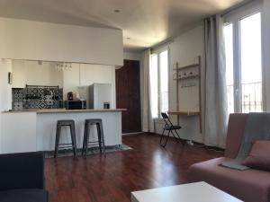 uma sala de estar com um sofá e uma cozinha em Studio Moustier em Marselha