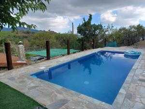 a swimming pool with blue water in a yard at Agrompelo House in Agros