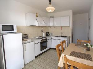 a kitchen with white appliances and a table with a dining room at Apartments Celine & Fabienne in Brodarica