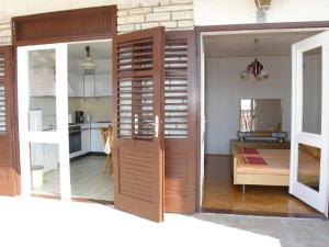 a kitchen with a sliding door and a dining room at Apartments Celine & Fabienne in Brodarica +42 photos