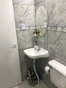 a bathroom with a sink and a mirror and a toilet at Departamento en Olavarría in Olavarría