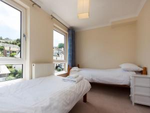 two beds in a room with two windows at Oakridge in Salcombe