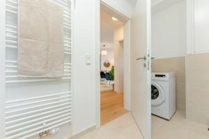 una lavanderia bianca con lavatrice e asciugatrice di Garden.Lounge Krems am Steinertor a Krems an der Donau